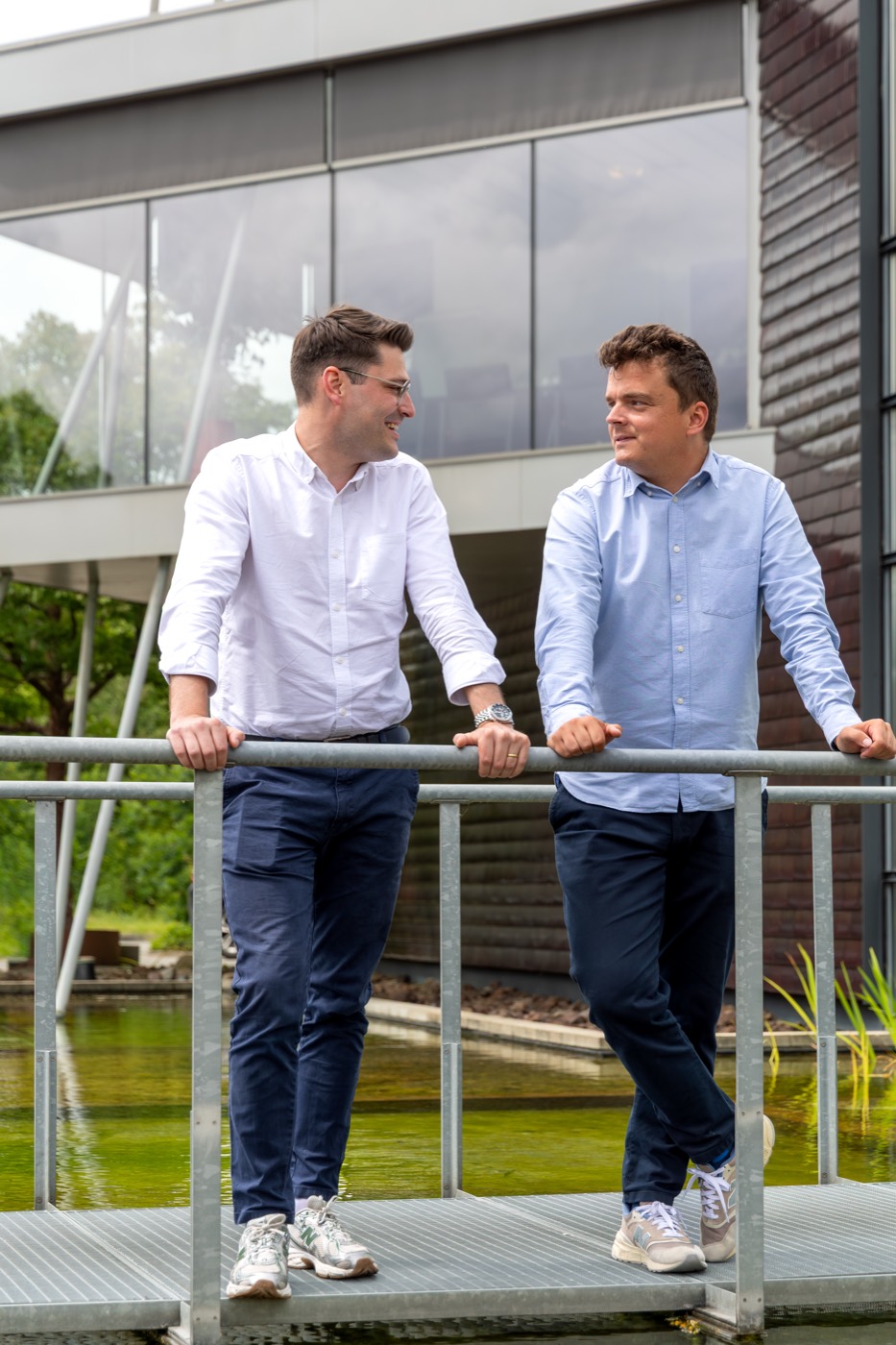 Twee ElmosExpert-collega's in gesprek op de brug aan het kantoor